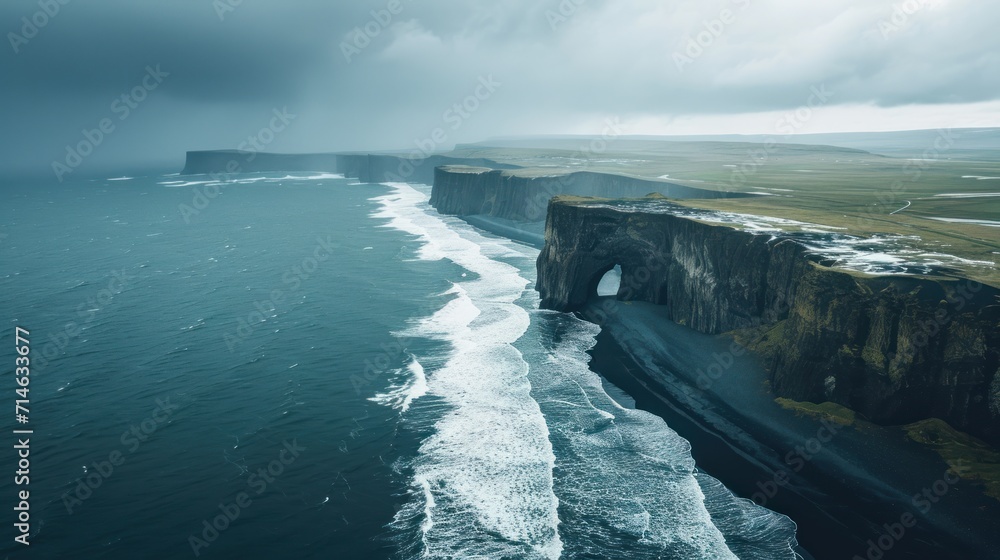 Poster an aerial view of a large body of water next to a large cliff with a tunnel in the middle of it and 