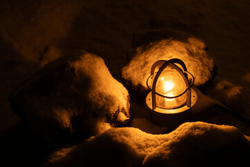 雪の中で暖かく輝くランプの灯り