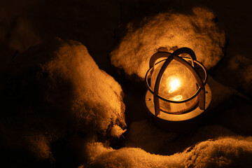 雪の中で暖かく輝くランプの灯り