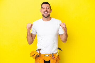 young electrician caucasian man isolated on yellow background celebrating a victory in winner...