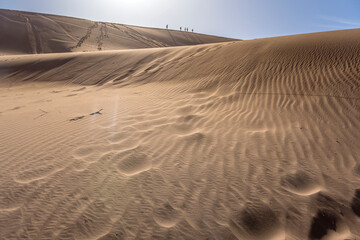 Fototapeta na wymiar tracks on sand of dune slope and climbers on dune edge , Naukluft desert, Deadlvei, Namibia