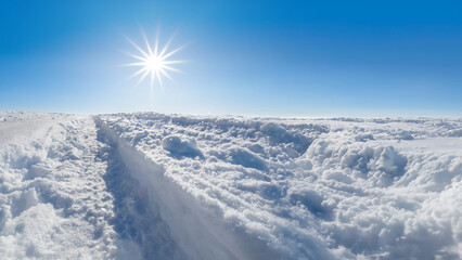 Fototapeta na wymiar Winter landscape with snow, blue sky and sun star