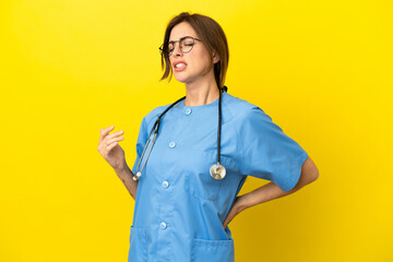 Surgeon doctor woman isolated on yellow background suffering from backache for having made an effort