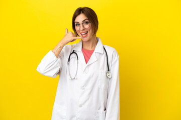 Doctor woman isolated on yellow background making phone gesture. Call me back sign