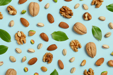 Different nuts on isolated light blue background. Top view of walnuts, pistachios and almonds. Flat lay. Source of omega 3 fatty acids and antioxidants. Healthy food concept. - obrazy, fototapety, plakaty