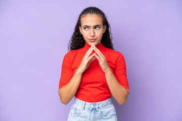 Young woman isolated on purple background scheming something