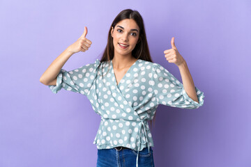 Young caucasian woman isolated on blue background giving a thumbs up gesture