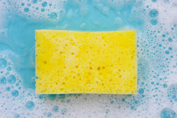 Cleaning sponge in foam of dishwashing liquid. Washing dishes concept