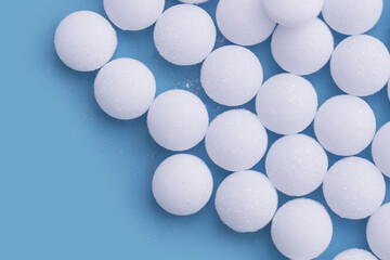 White mothballs on blue background.
