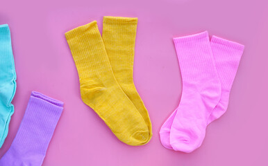 Colorful socks on pink background.