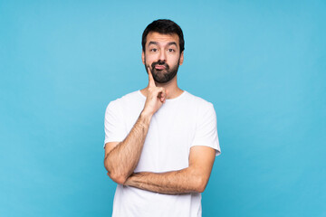 Young man with beard  over isolated blue background Looking front