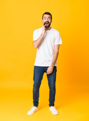 Fototapeta na wymiar Full-length shot of man with beard over isolated yellow background with surprise and shocked facial expression