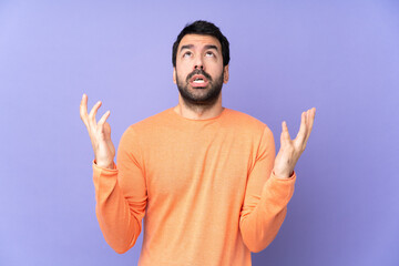 Caucasian handsome man over isolated purple background frustrated by a bad situation