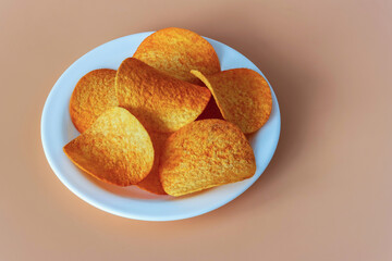 Round crispy potato chips on orange background
