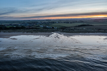 Stunning aerial drone landscape image of Northumberland beach in Northern England during Winter sunrise