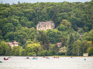 Casa en medio del bosque en la montaña con vistas a un lago con barcas