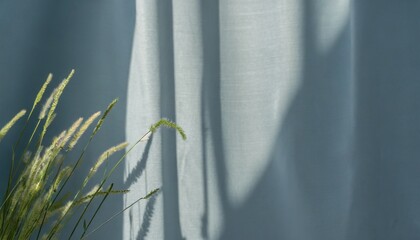 minimalist aesthetic natural summer background with blurry sunlight shadow of meadow grass on neutral blue gray curtain copy space - obrazy, fototapety, plakaty