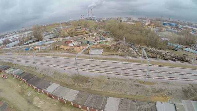 City outskirts with railroad at spring cloudy day. Aerial view