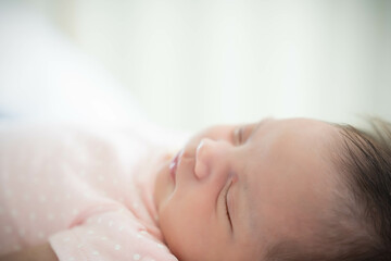 Close up Newborn Baby face Newborn Baby Girl sleeping on cozy bed Infant mixed race baby get sweet dream and good sleeping until morning