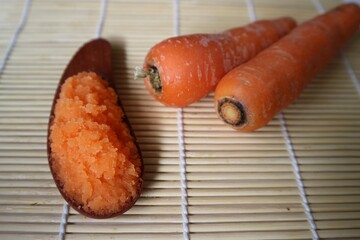 Organic carrots pulp juice on wooden spoon, squeezed from a slow juicer, for face mask or processed...
