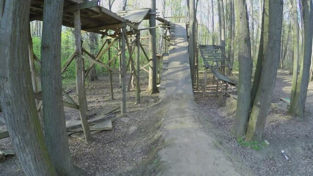 Broken wooden construction for dirt jumping on bicycles in park at spring