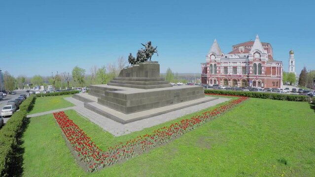 Monument of Chapaev and grassplot with flowers around at spring