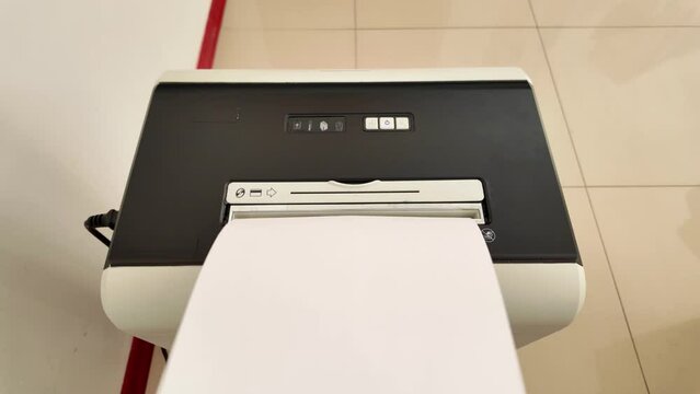 Close-up of shredding a paper on paper shredder for safety and privacy in a workplace.