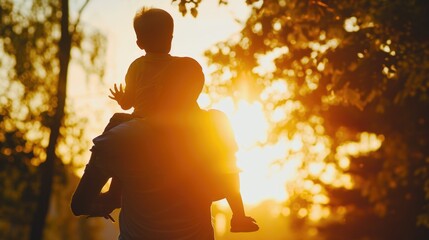 father and son in the park. father's day silhouette happy family child dream concept. father carries his son on his back. dad playing with his son in nature in the park silhouette at sunset lifestyle 