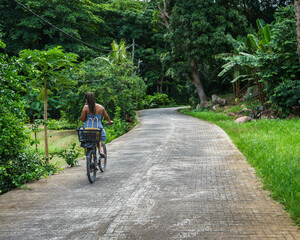 Woman Cycling in La Digue. Seychelles  - 714700237
