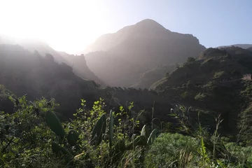 Foto op Canvas Misty mountain landscape from La Hermigua in La Gomera, Canary Islands, Spain with famous Roques de San Pedro (Twin rocks of Hermigua), iconic rock formation © Iwona