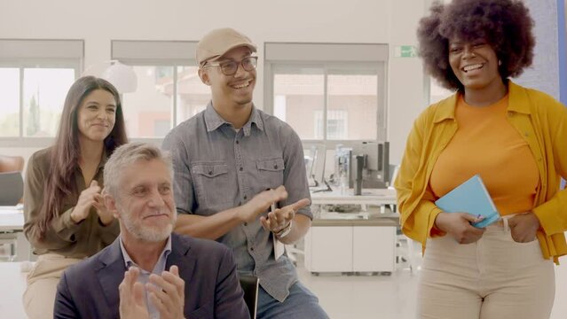 Team congratulating an african colleague in the coworking office