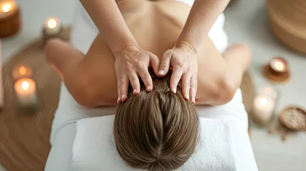 Fotobehang Massagesalon young woman with a serene expression receiving a shoulder massage at a spa
