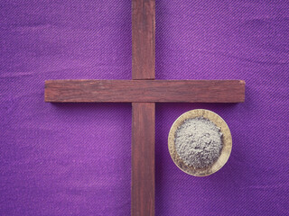 Christianity concept about Ash Wednesday, Good Friday, Lent Season and Holy Week. A holy cross and holy ash on a purple background . With blurred style background.
