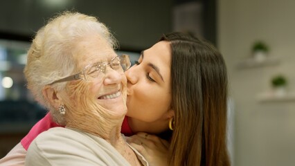 Granddaughter kissing her grandmother with lots of love