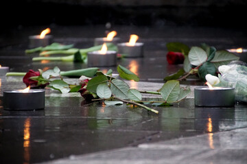 Roses and candles on wet street - obrazy, fototapety, plakaty