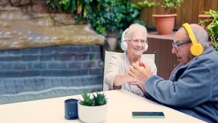 Senior couple listening to music and congratulating each other