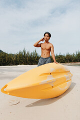 Obraz premium Happy Asian Man Kayaking on a Tropical Beach: Enjoying an Active Summer Vacation