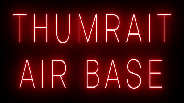 Flickering red retro style neon sign glowing against a black background for THUMRAIT AIR BASE