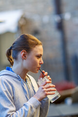 caucasian young cool red haired barista mixing a a cocktail in shaker with energy outdoors