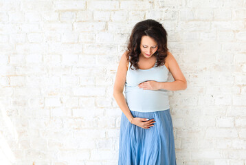 Pregnant woman touching her belly with hands