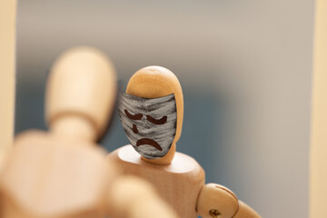 The figure of a man bowed his head in front of the mirror as a sign of sorrow, sadness.