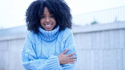 African woman gesturing cold in the street - obrazy, fototapety, plakaty