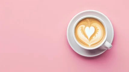 Foto op Plexiglas Close-up view of a cup of coffee with heart shape latte art over pink background. © Joyce