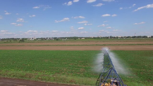 Farm field wetting at summer sunny day. Aerial view