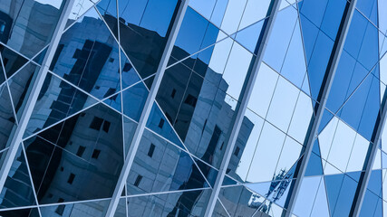 Architecture of the facade of the building from blue glass panels with reflections