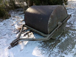 A large trailed metal roller for leveling the road surface. Tool for repair road works. The topic...