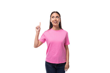 young promoter good-looking woman with black hair dressed in a pink t-shirt is gesturing on a white background with copy space. advertising concept