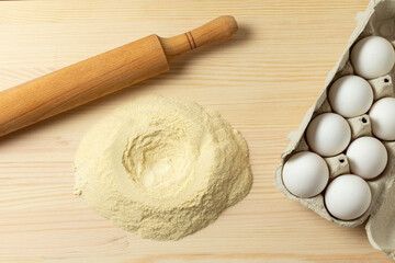 Fototapeta na wymiar Durum wheat flour, rolling pin and eggs. Preparation of fresh pasta.