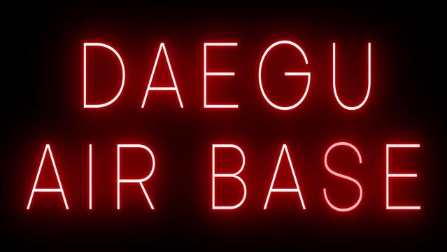 Flickering red retro style neon sign glowing against a black background for DAEGU AIR BASE
