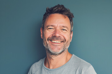 Fototapeta premium A man with a beard is smiling in front of a blue wall